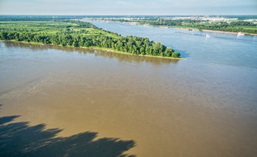 Missouri and Mississippi River confluence with suspended soil in the water.